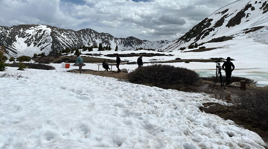 Film crew building a set in a snowy mountain landscape