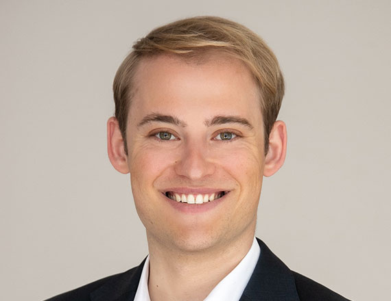 Michael von Hassel, Director Digitalization Office at TÜV SÜD, is wearing a dark suit and a white shirt, smiling into the camera.