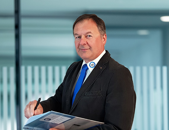 Norbert Kraus: A man in a business outfit stands in an office and takes notes.
