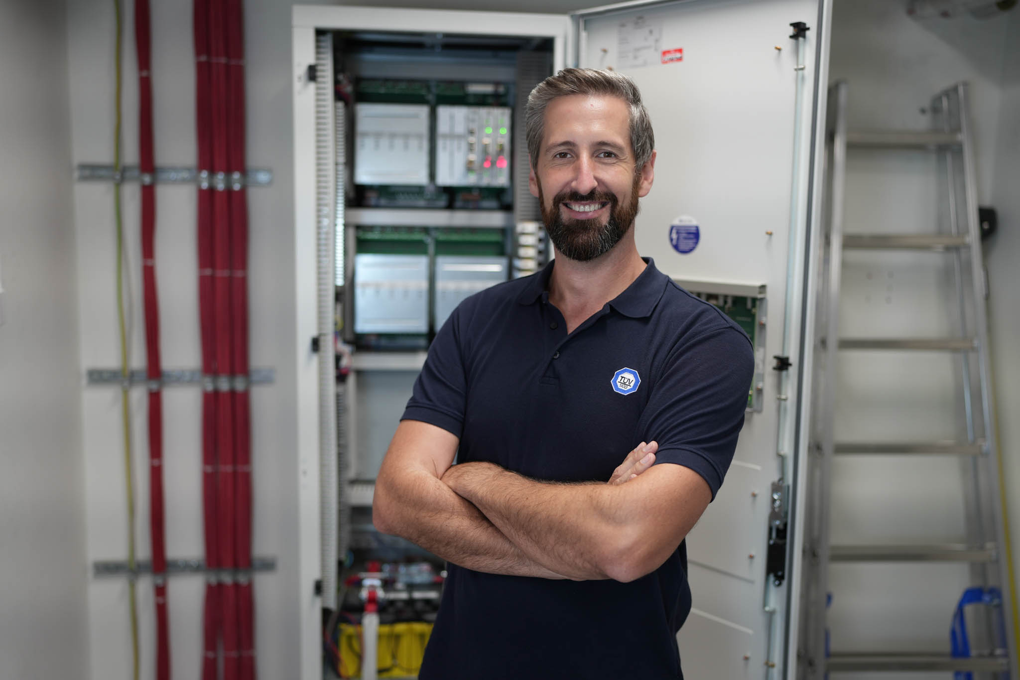 Mann steht mit verschränkten Armen im Technik-Raum eines Gebäudes.