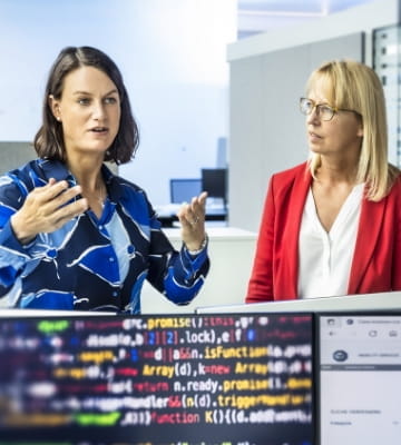 Zwei Mitarbeiterinnen diskutieren fachlich über ein IT-Thema