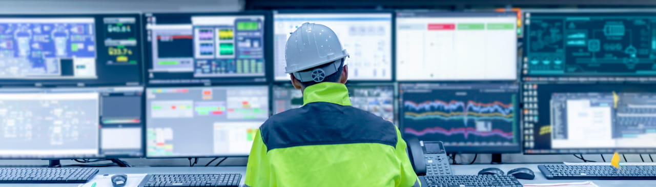 Ingenieur im Kontrollraum mit vielen Monitoren