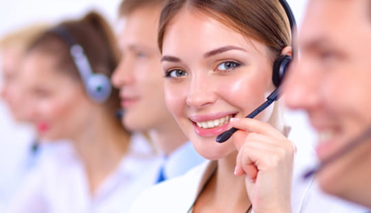 Lächelnde, junge Menschen in Business-Kleidung in einem Call-Center