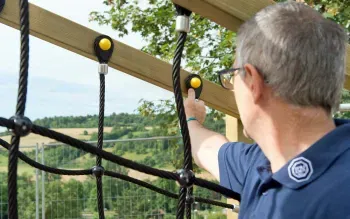 Spielplatzprüfer kontrolliert Klettergerüst