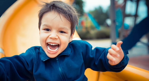 Junge auf Rutsche Spielplatzprüfung