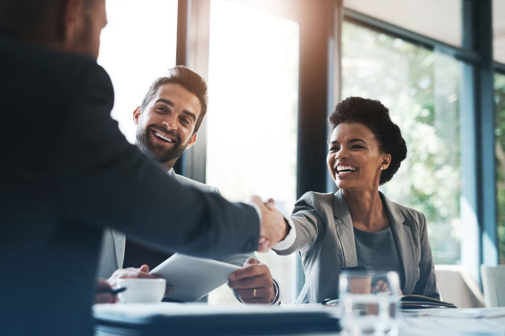 Geschäftspartner im Büro geben sich die Hand als Symbol für Global Market Access