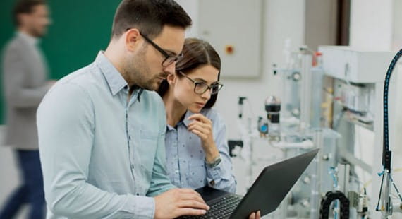 Zwei Experten überprüfen elektrische Sicherheitsmaßnahmen in einer Produktionsanlage.