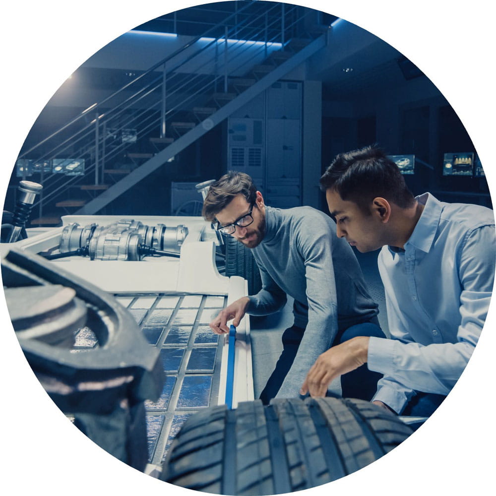Two automotive engineers are working on a structure for an electric car where the batteries will be located.