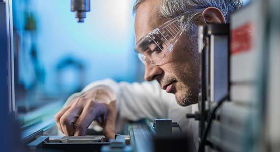 Ingénieur en lunettes de protection travaillant sur une machine.