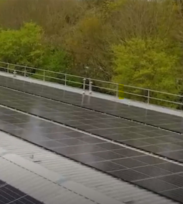 solar panels on grey roof with background of trees