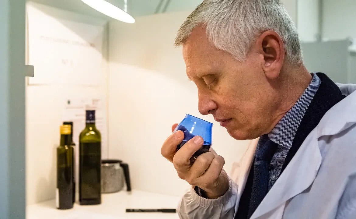 Tecnico di laboratorio che annusa l'olio da una provetta