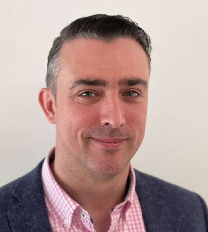 Darren Hugheston-Roberts wearing pink shirt and grey suit jacket