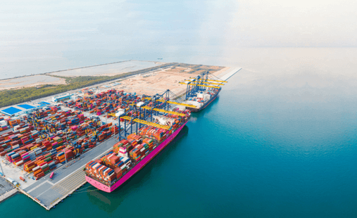 Một con tàu lớn chở hàng đang ở cảng biển, với nước biển xanh trong, đáp ứng chương trình an ninh CTPAT