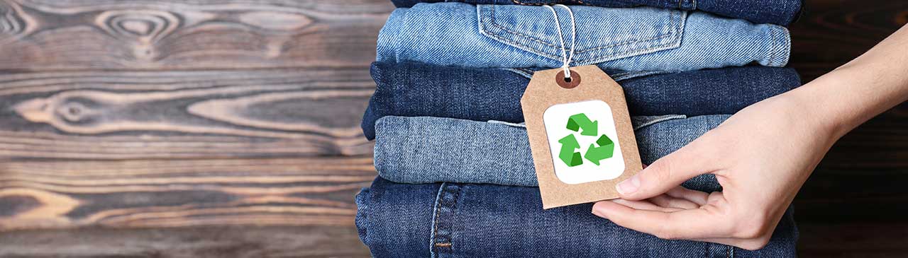 Gestapelte Jeans mit einem Anhänger mit Ökolabel